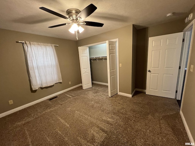 unfurnished bedroom with ceiling fan, a closet, dark carpet, and a textured ceiling