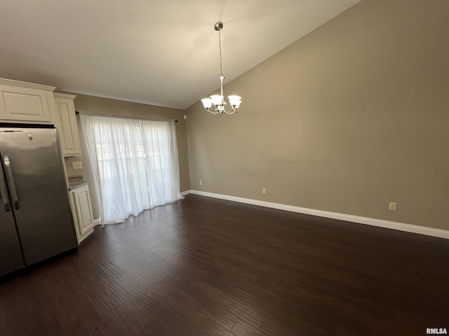 interior space with lofted ceiling, a chandelier, stainless steel refrigerator, dark hardwood / wood-style flooring, and white cabinets