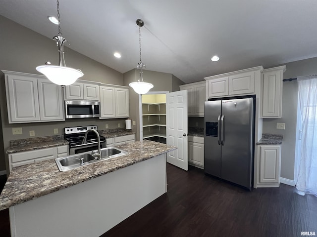 kitchen featuring white cabinetry, decorative light fixtures, a center island with sink, and appliances with stainless steel finishes