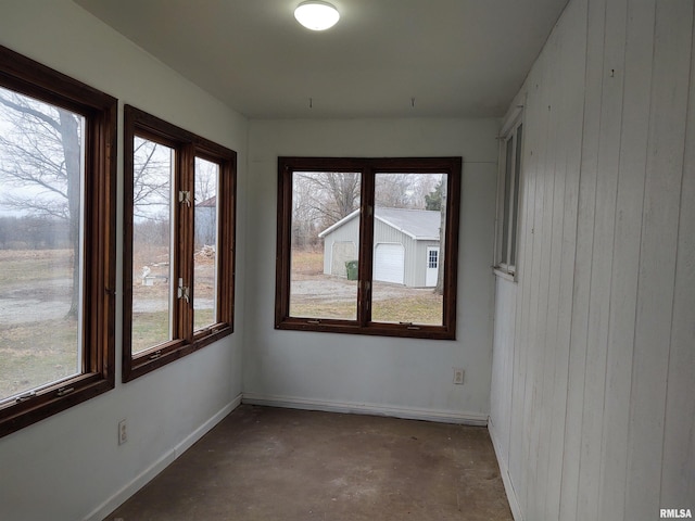 8027 Shawnee College Rd, Ullin, IL 62992 - unfurnished room featuring unfinished concrete flooring, wood walls, and baseboards