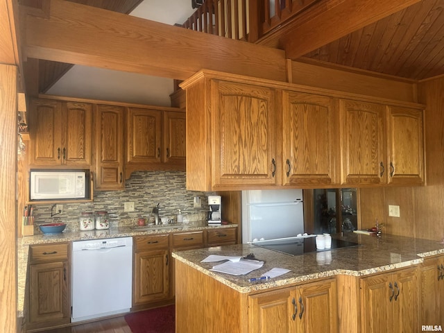 kitchen with sink, tasteful backsplash, kitchen peninsula, stone counters, and white appliances