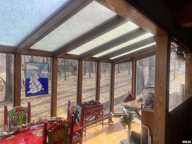 sunroom featuring lofted ceiling with beams