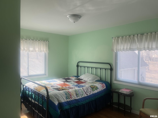 bedroom featuring dark hardwood / wood-style flooring and multiple windows