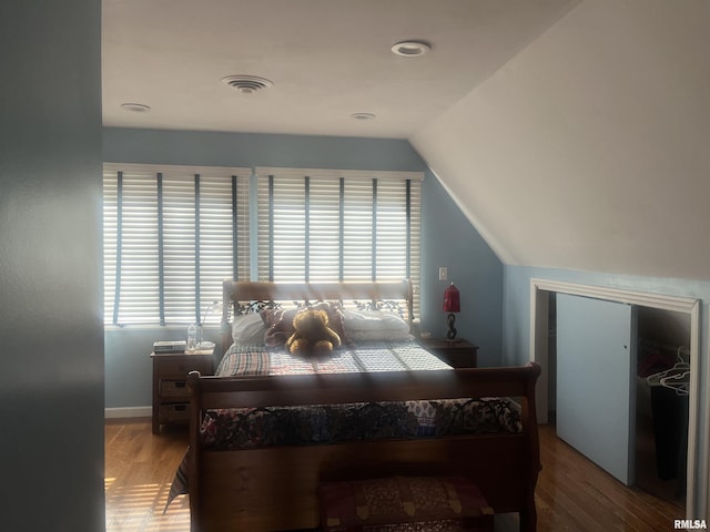 bedroom featuring lofted ceiling, wood-type flooring, and a closet