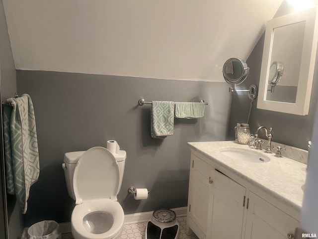 bathroom with vanity, toilet, and vaulted ceiling