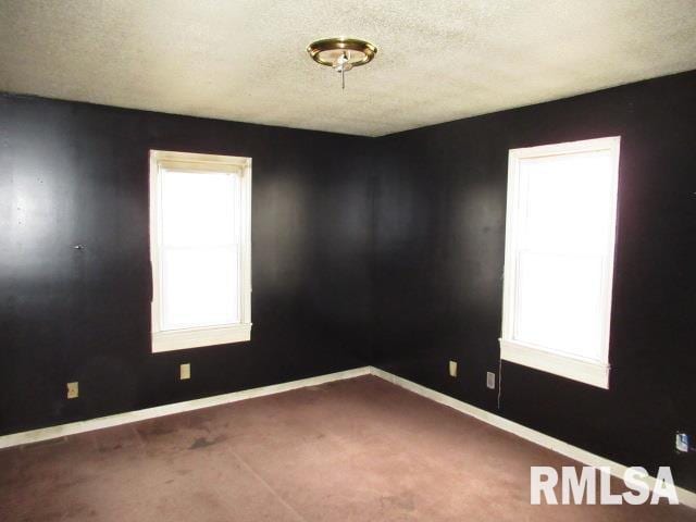 carpeted spare room with a textured ceiling