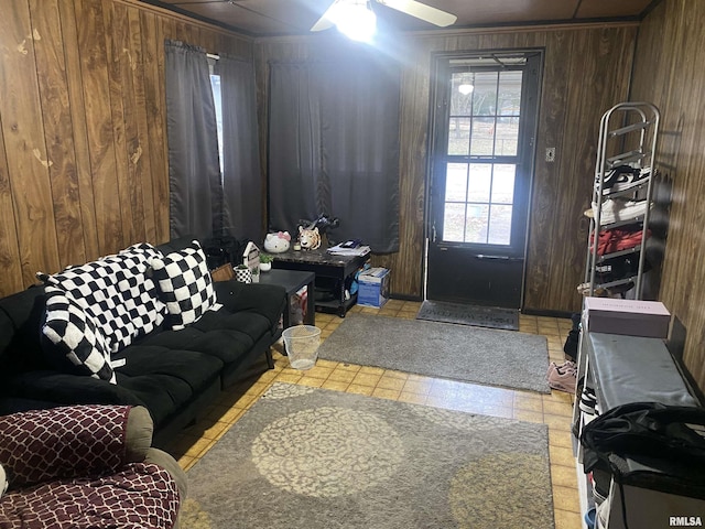 living room with ceiling fan and wooden walls