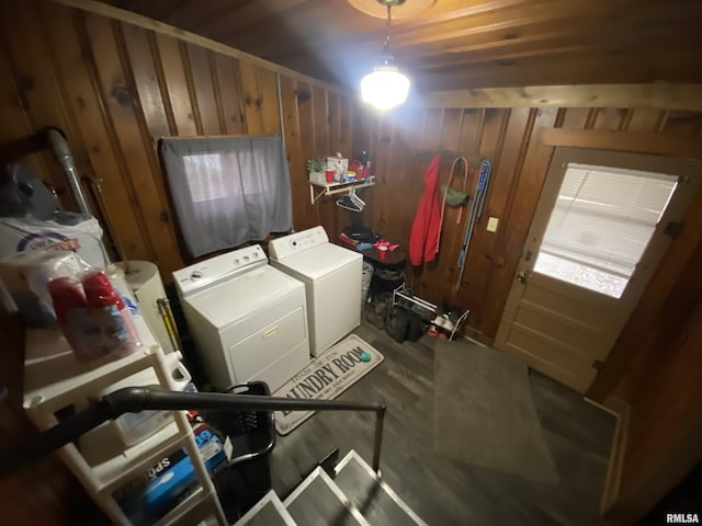 clothes washing area featuring wooden walls and washer and dryer