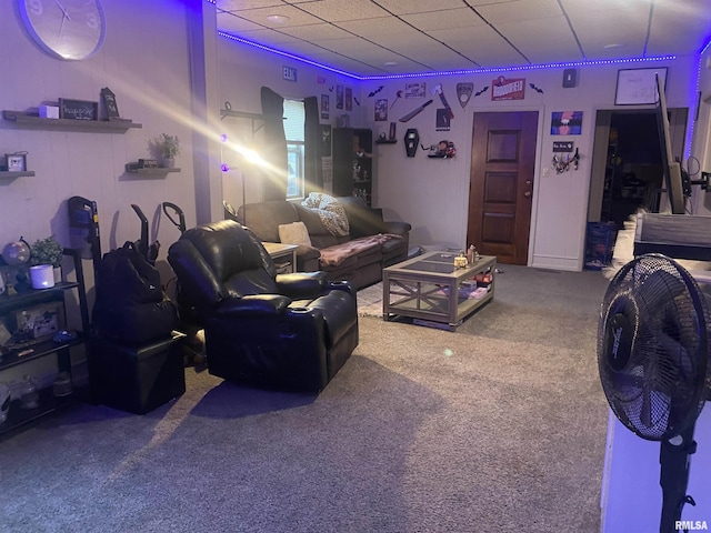 living room featuring a paneled ceiling and carpet floors