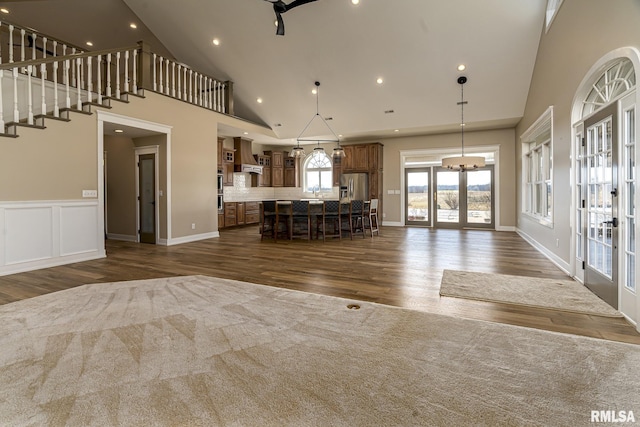 unfurnished living room featuring french doors, dark hardwood / wood-style floors, and high vaulted ceiling