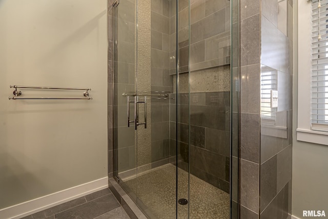 bathroom featuring a shower with shower door and tile patterned floors