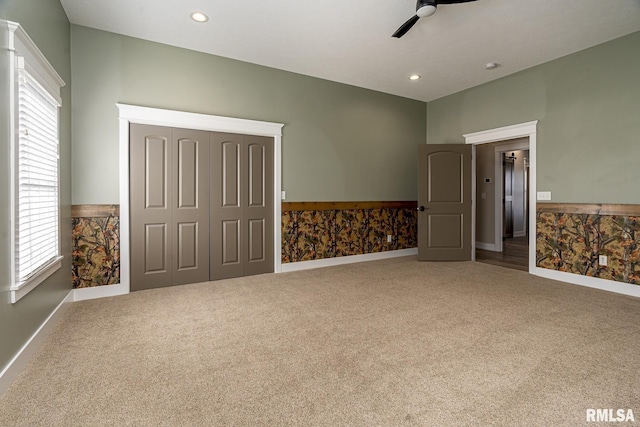 unfurnished bedroom featuring carpet floors, elevator, ceiling fan, and a closet