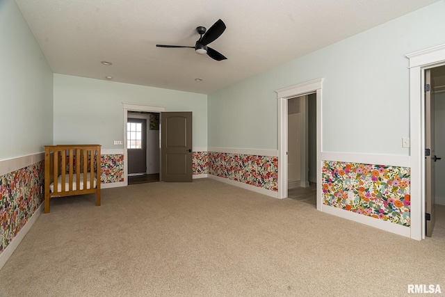 unfurnished bedroom featuring light carpet and ceiling fan