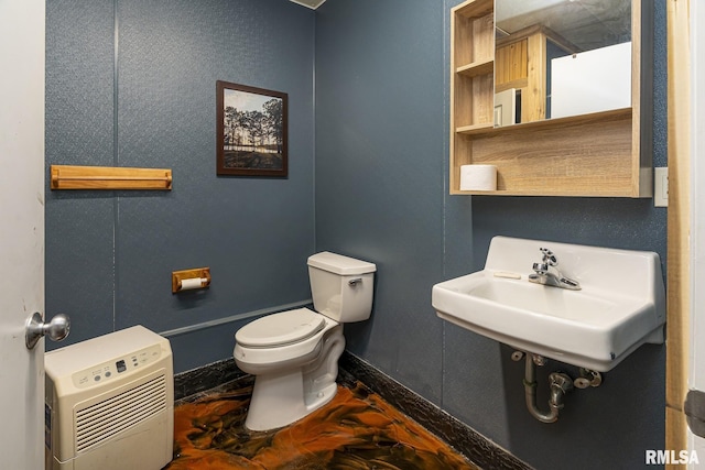 bathroom with heating unit, sink, and toilet