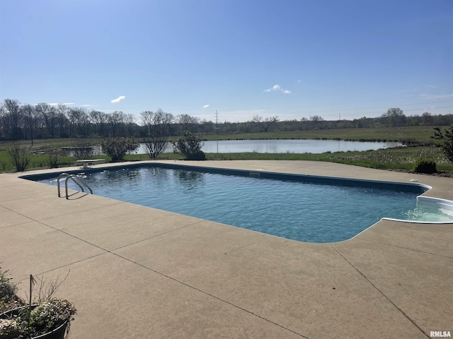 outdoor pool with a patio and a diving board