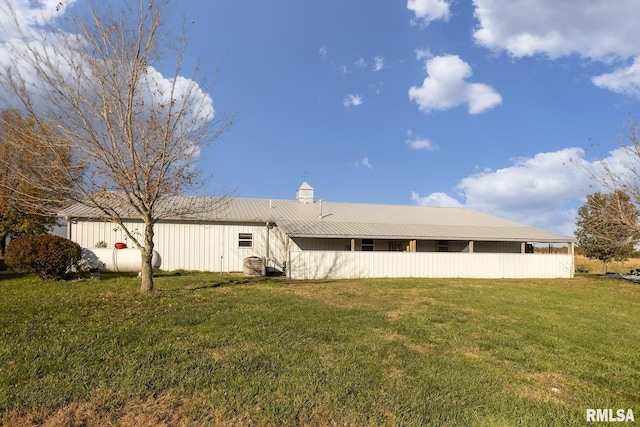 rear view of house featuring a lawn