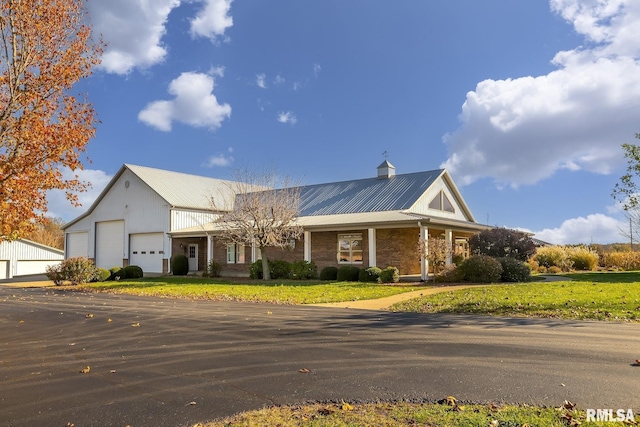 view of front of home featuring a garage, a front yard, and brick siding