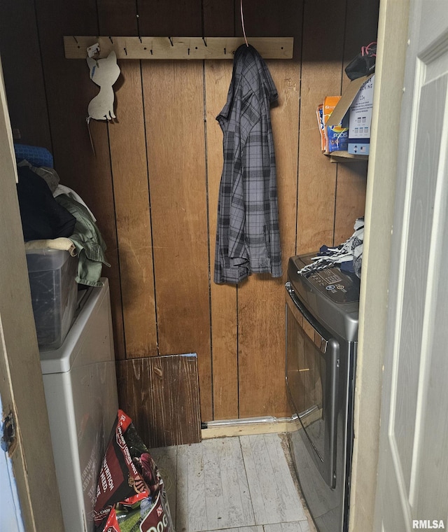 laundry room with washing machine and dryer and light hardwood / wood-style flooring