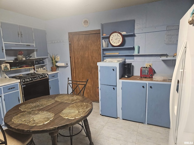 kitchen with electric stove, blue cabinets, and white refrigerator