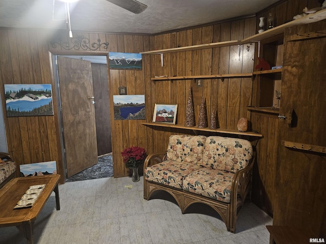 living area featuring ceiling fan, wooden walls, and light hardwood / wood-style flooring