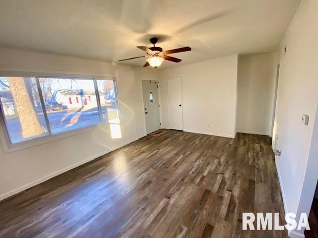 unfurnished room featuring dark wood-type flooring and ceiling fan