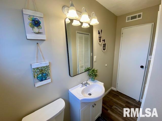 bathroom featuring vanity, toilet, a chandelier, and hardwood / wood-style floors