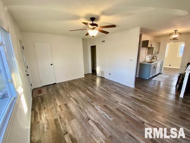 unfurnished living room with ceiling fan, sink, and dark hardwood / wood-style flooring