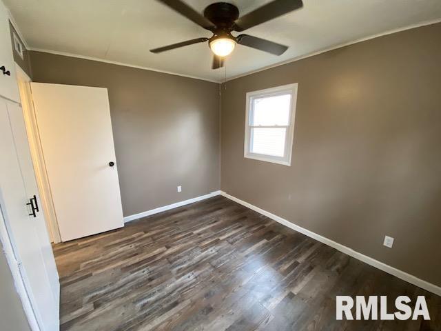 unfurnished bedroom with crown molding, dark wood-type flooring, and ceiling fan