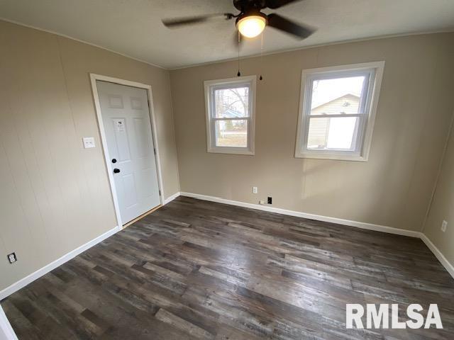 empty room featuring ceiling fan and dark hardwood / wood-style flooring