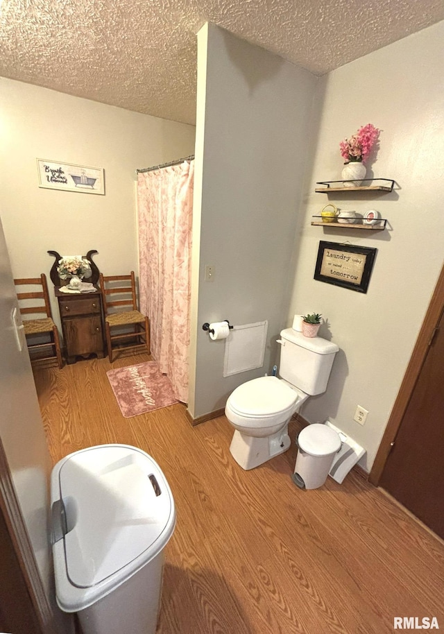 bathroom featuring hardwood / wood-style flooring, a textured ceiling, and toilet