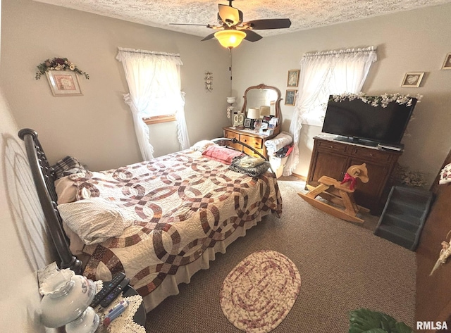 bedroom featuring ceiling fan, carpet floors, and a textured ceiling