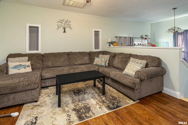 living room featuring an inviting chandelier and dark hardwood / wood-style flooring