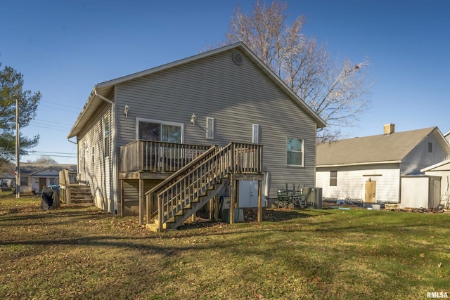 rear view of house with a deck and a lawn