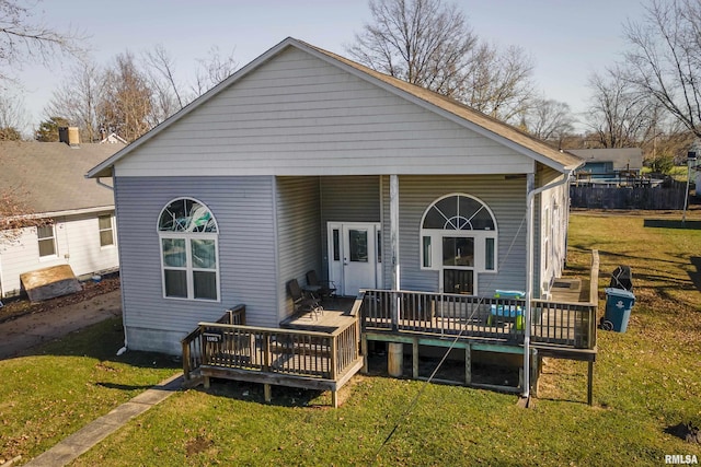 back of property with a wooden deck and a yard