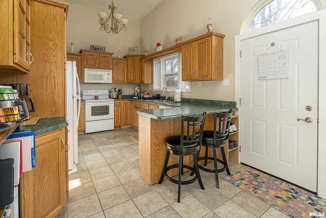 kitchen with pendant lighting, light tile patterned floors, white appliances, sink, and a kitchen breakfast bar