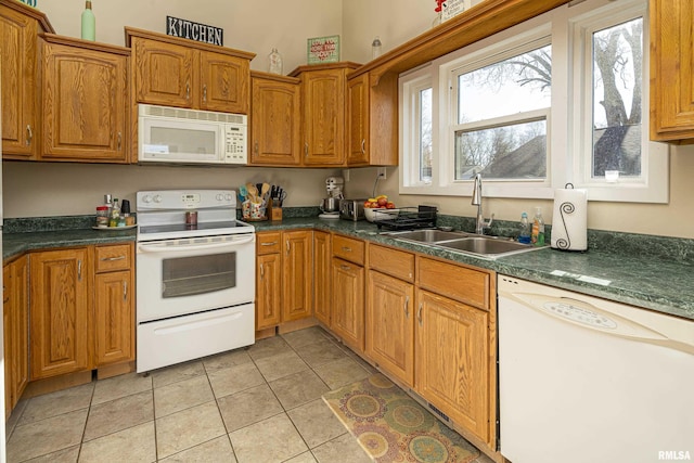 kitchen with white appliances, sink, and light tile patterned floors