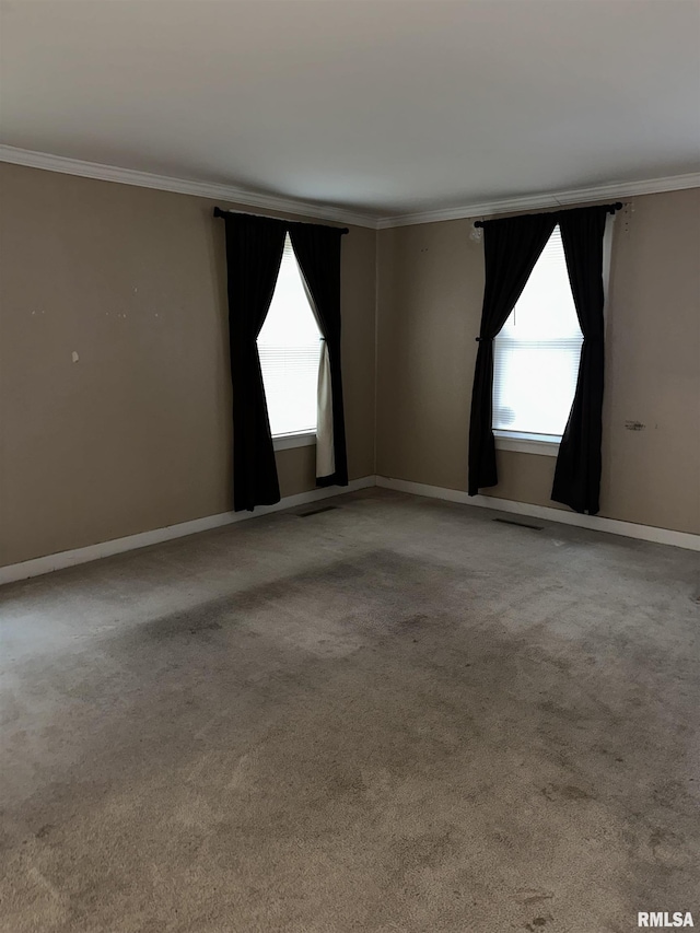 empty room featuring crown molding and light colored carpet