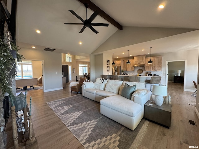 living room featuring beam ceiling, high vaulted ceiling, dark hardwood / wood-style floors, and ceiling fan