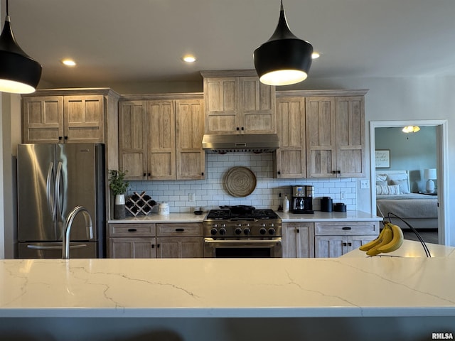 kitchen with pendant lighting, light stone counters, decorative backsplash, and stainless steel appliances