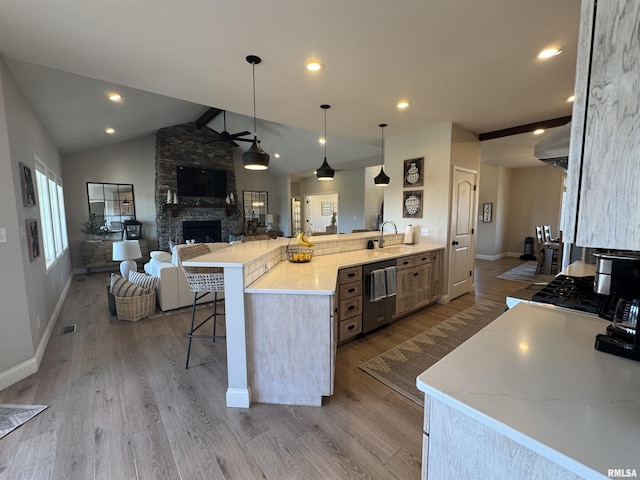 kitchen featuring sink, a kitchen breakfast bar, hanging light fixtures, kitchen peninsula, and stainless steel appliances