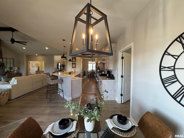 dining area with ceiling fan, lofted ceiling, and wood-type flooring