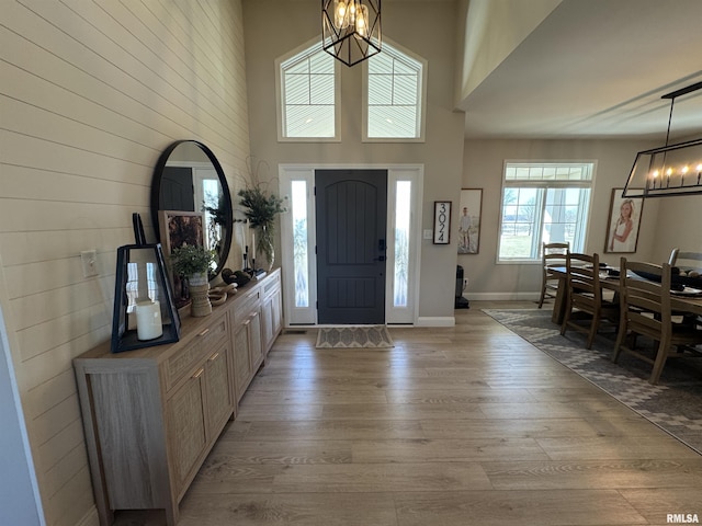 entryway featuring a high ceiling, a notable chandelier, and light hardwood / wood-style floors