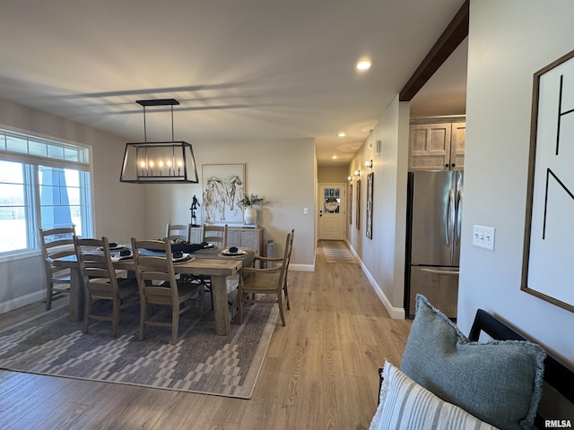 dining space featuring an inviting chandelier and light wood-type flooring