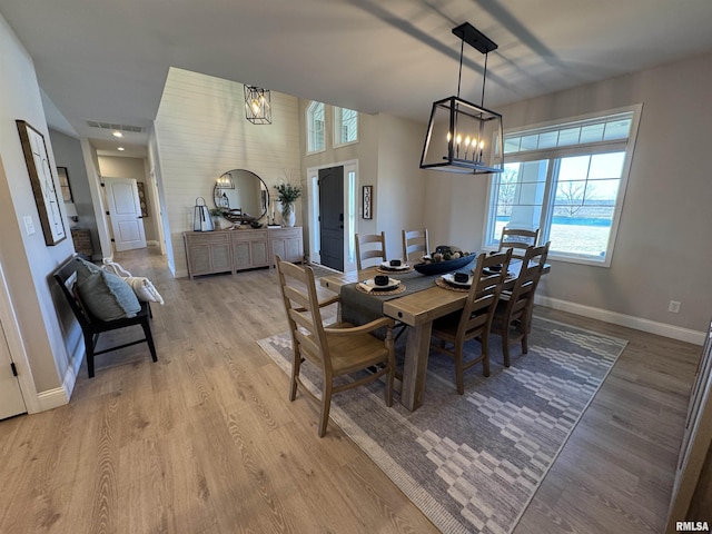 dining area featuring a notable chandelier and light wood-type flooring