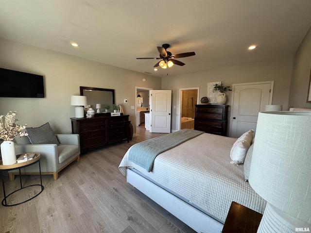 bedroom featuring ceiling fan, ensuite bath, and light hardwood / wood-style flooring