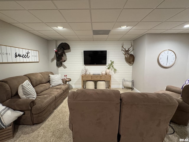 carpeted living room featuring a drop ceiling