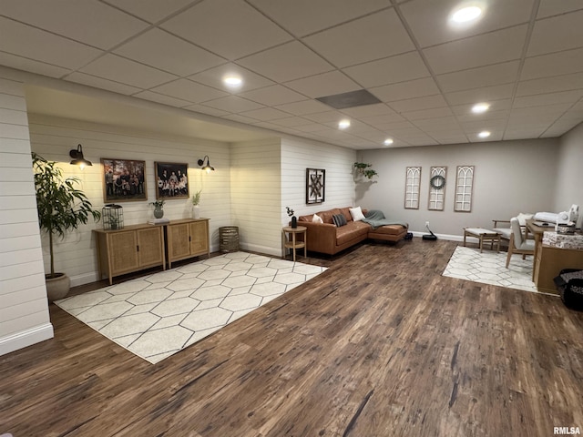 living room featuring wood-type flooring and a drop ceiling