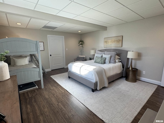 bedroom featuring dark hardwood / wood-style flooring and a drop ceiling