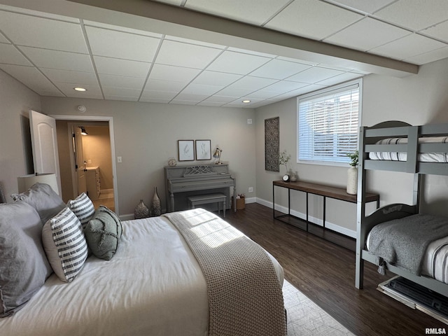 bedroom featuring dark wood-type flooring and a drop ceiling