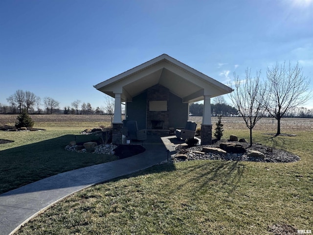 view of yard featuring a rural view and an outdoor fireplace